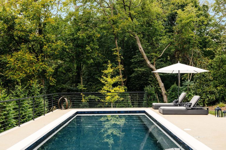 Mid-sized mid-century modern backyard concrete and rectangular lap pool photo in Nashville