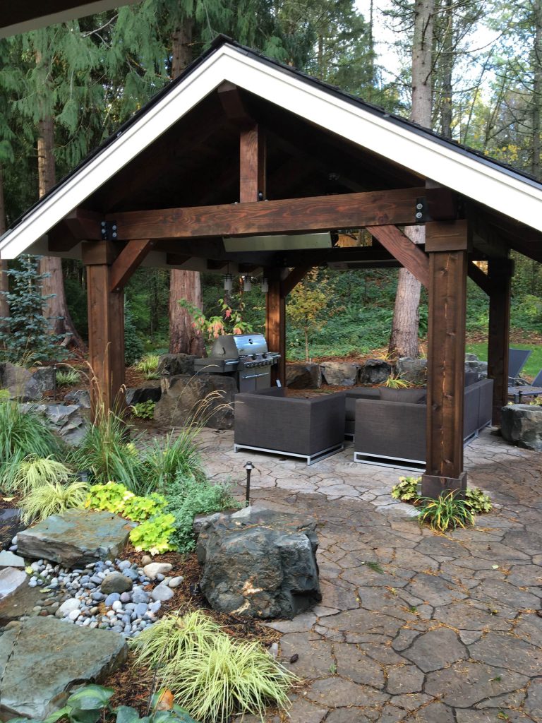 Mid-sized minimalist backyard stone patio kitchen photo in Seattle with a gazebo