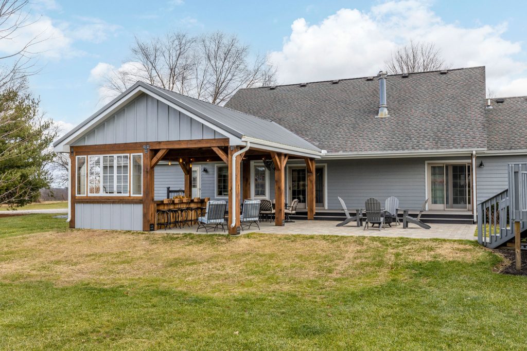 Mid-sized mountain style backyard brick patio kitchen photo in Columbus with a roof extension
