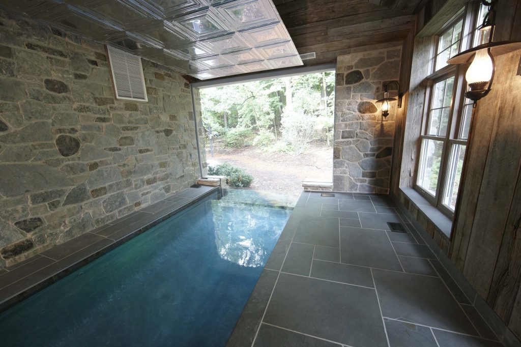 Mid-sized mountain style indoor tile and rectangular infinity pool photo in Milwaukee