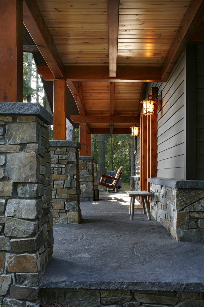 Mid-sized mountain style stamped concrete front porch photo in Other with a roof extension by Bouril Design Studio, LLC | Outdoor Photos | Porch | Landscaping | Landscape Design | Outdoor Living Space | Porch Design Ideas | Outdoor Living Space Ideas | Backyard Design