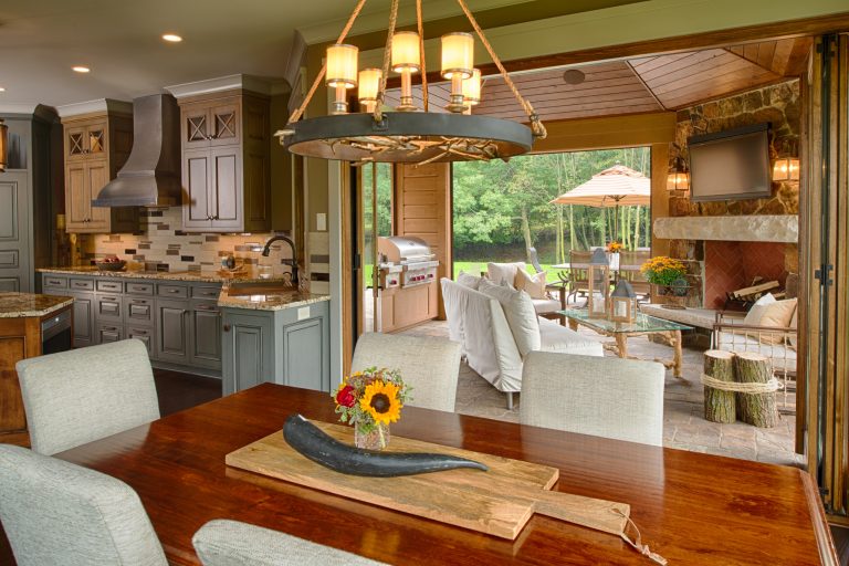 Mid-sized mountain style stone back porch idea in Minneapolis with a fire pit and a roof extension by Studio M Interiors | Outdoor Photos | Porch | Landscaping | Landscape Design | Outdoor Living Space | Porch Design Ideas | Outdoor Living Space Ideas | Backyard Design