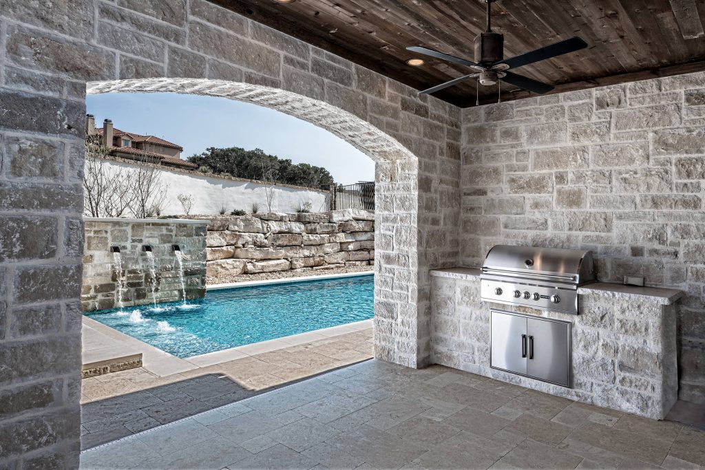 Mid-sized transitional backyard stamped concrete patio kitchen photo in Austin with a roof extension