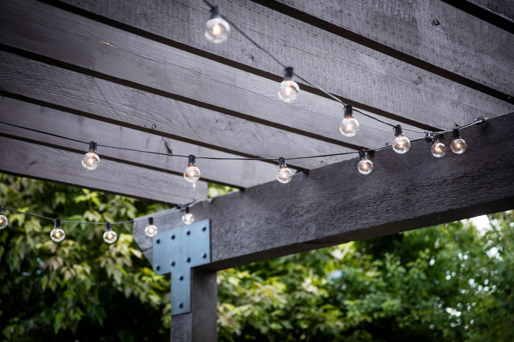 Mid-sized trendy backyard concrete paver patio kitchen photo in Denver with a pergola