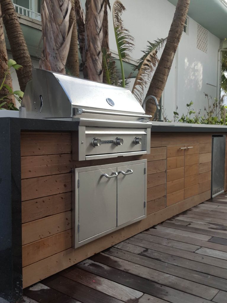 Mid-sized trendy backyard outdoor kitchen deck photo in Miami with no cover