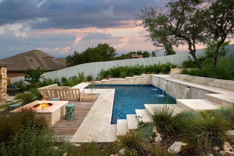 Mid-sized trendy backyard stone and l-shaped natural pool fountain photo in Austin