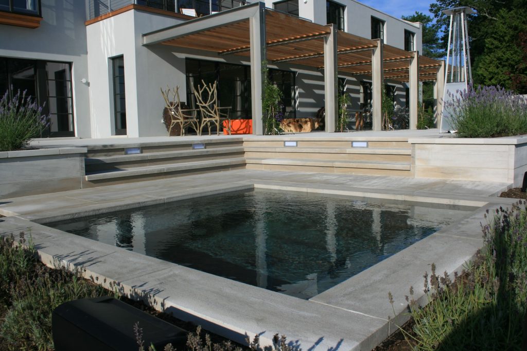 Mid-sized trendy backyard stone and rectangular lap hot tub photo in New York