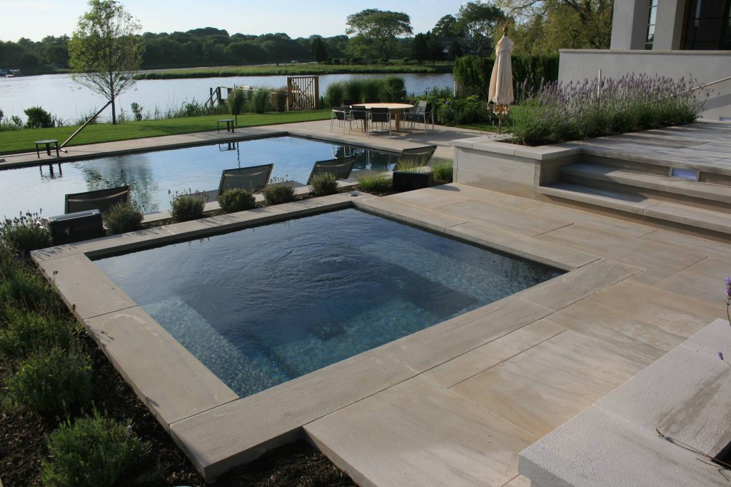 Mid-sized trendy backyard stone and rectangular lap hot tub photo in New York