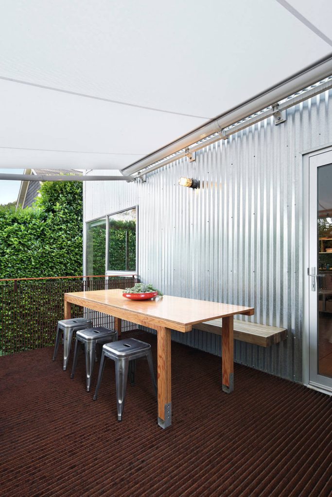 Mid-sized urban backyard deck photo in Seattle with an awning