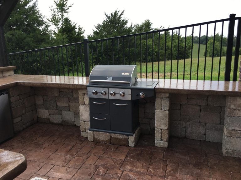 Minimalist backyard brick patio kitchen photo in Other with a pergola