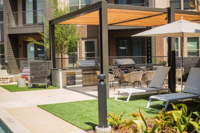 Minimalist courtyard concrete patio kitchen photo in Dallas with a pergola
