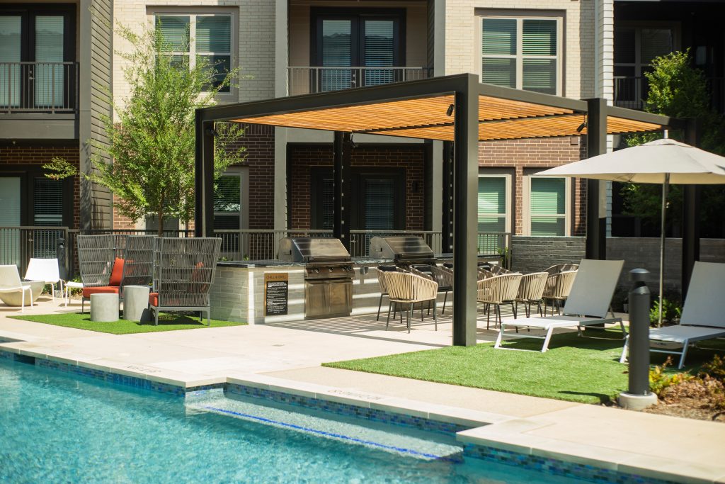 Minimalist courtyard concrete patio kitchen photo in Dallas with a pergola