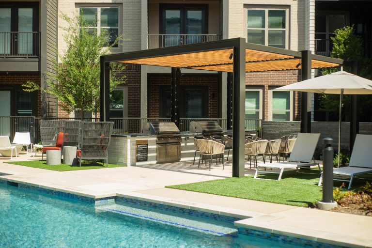 Minimalist courtyard concrete patio kitchen photo in Dallas with a pergola