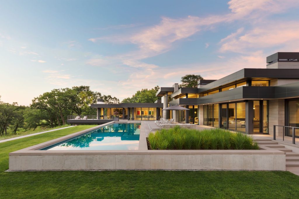 Modern luxury lake home with lap pool and exterior of steel and limestone. Award-winning Architectural Design.