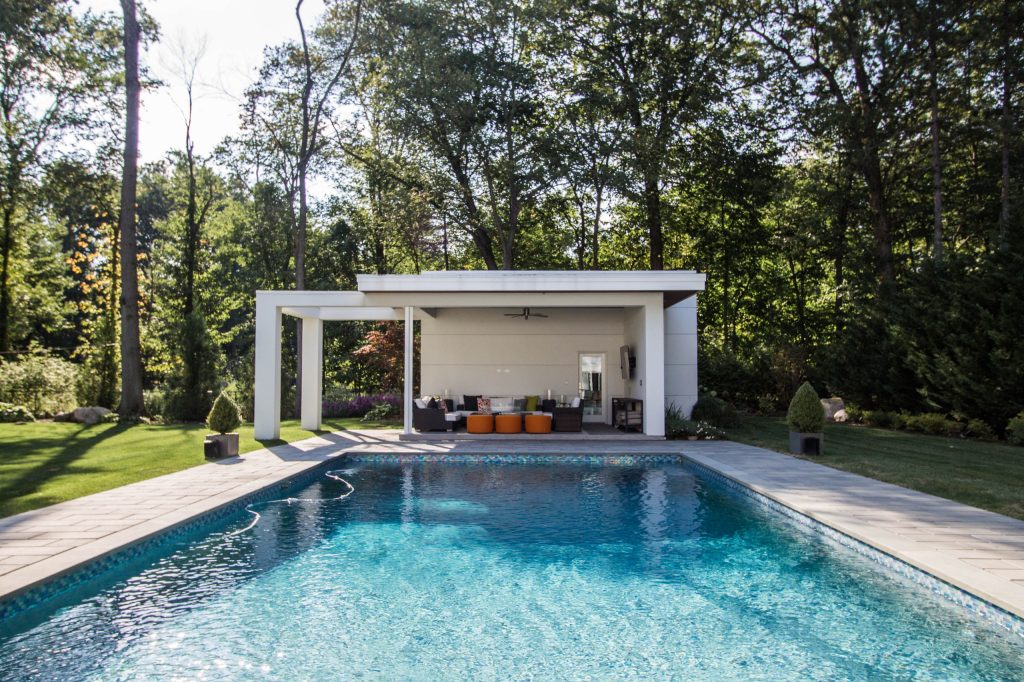 Modern white pool house with cantilevered design.