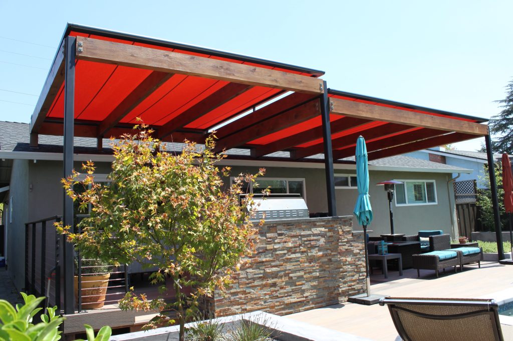 Motorized roof shade systems integrated onto a dual height, 2-section arbor over dining and sitting areas.