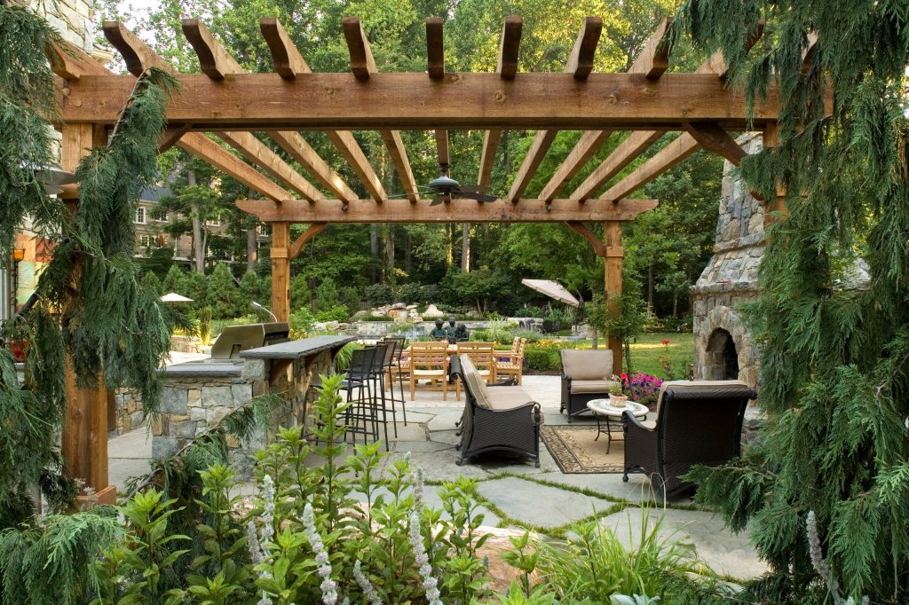Mountain style backyard concrete paver patio kitchen photo in DC Metro with a pergola