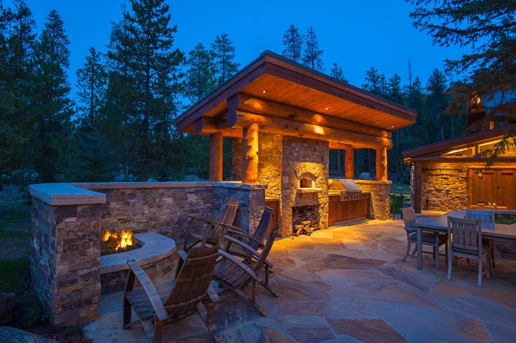 Mountain style side yard stone patio kitchen photo in Denver