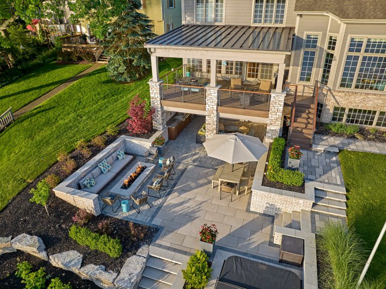 Multi-level lakeside terrace with covered outdoor kitchen, hot tub, built-in fire pit and outdoor bar