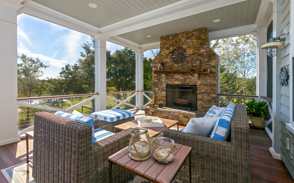 Natural-Stone Fireplace, Detailed Porch Design, and Cozy Wicker Seating at a Custom Lowcountry Home