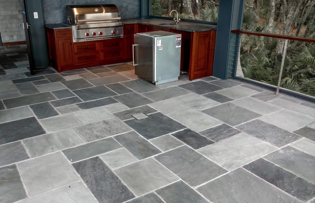 Natural cleft stone sawed in ashlar pattern with stone infinity drain in center of floor