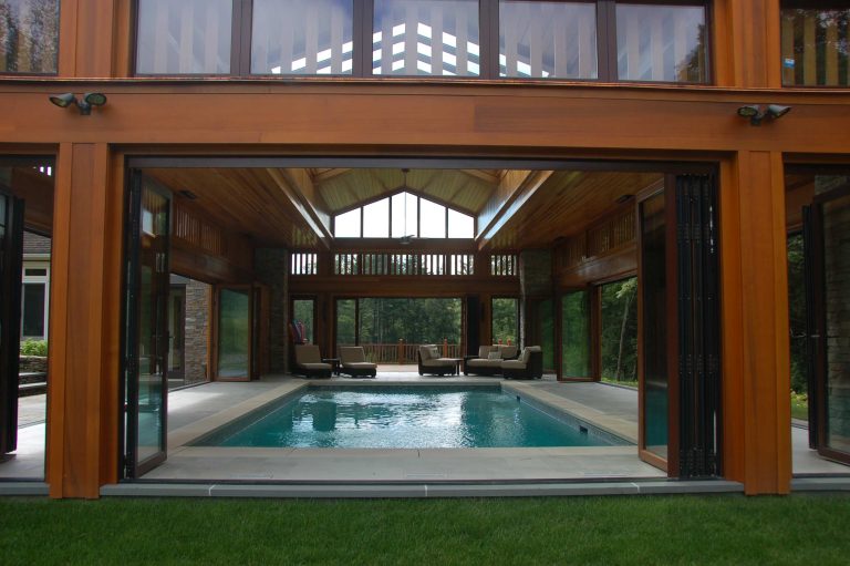 Nestled in the Berkshire Mountains, the poolhouse opens completely to the outdoors during warm months via sliding doors that fold away. In winter, swimmers can enjoy the water while watching the snow fall.