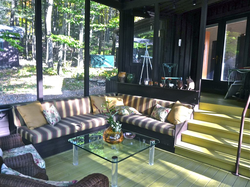 New screened in porch with built in sofa. Floor is painted chartreuse
