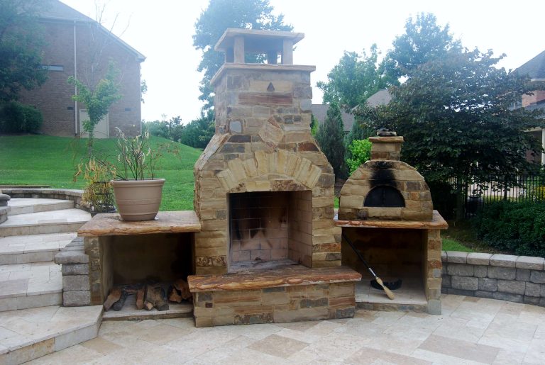 Outdoor Kitchen with a fireplace & pizza oven. Here you will find travertine flooring, natural stone counter-tops, natural stone column caps, as well as natural thin stone veneer.