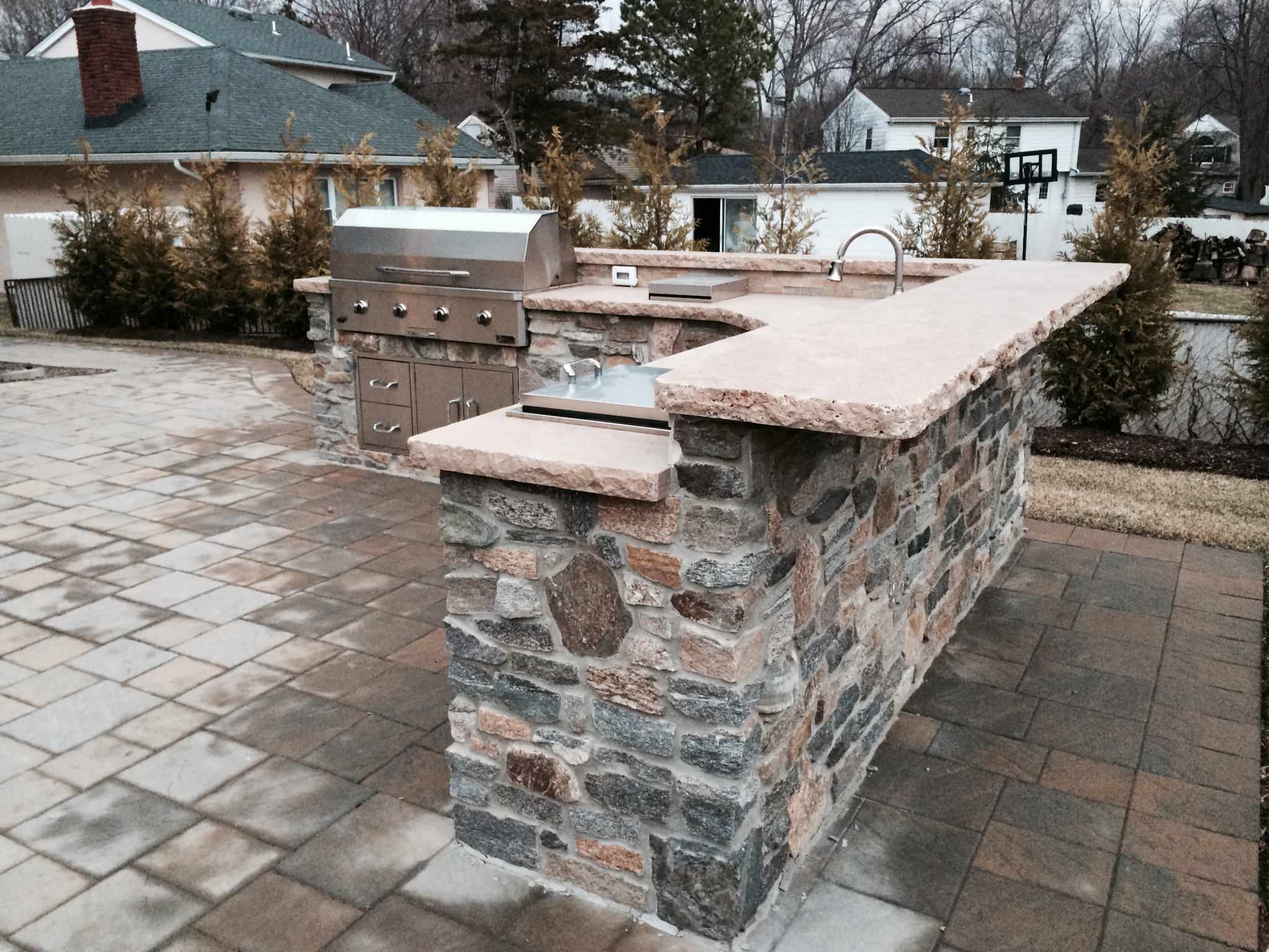 Outdoor Living of NJ
Example of a mid-sized mountain style backyard concrete paver patio kitchen design in New York with no cover
