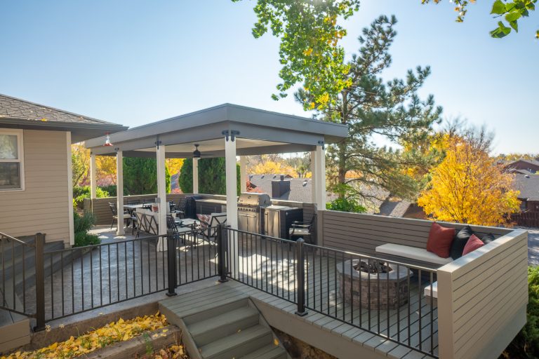 Outdoor entertaining kitchen. Stamped stained concrete, granite top, Stainless Steel grill, outdoor refrigerator, and storage. Fire pit with seating.