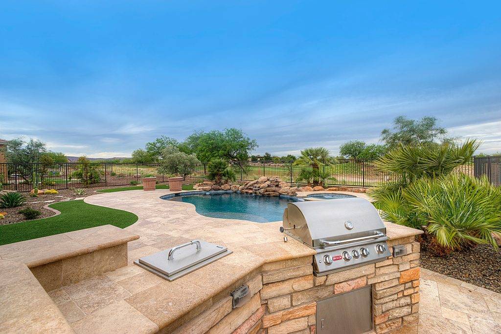 Outdoor grill and cooking araa overlooking freeform outdoor pool