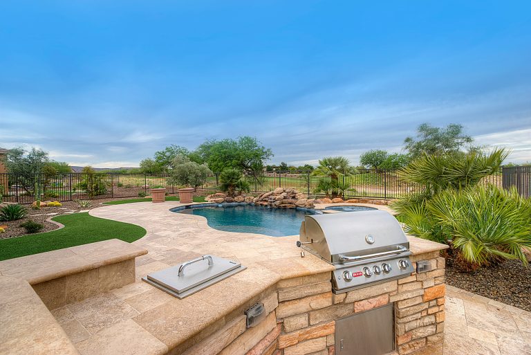 Outdoor grill and cooking araa overlooking freeform outdoor pool