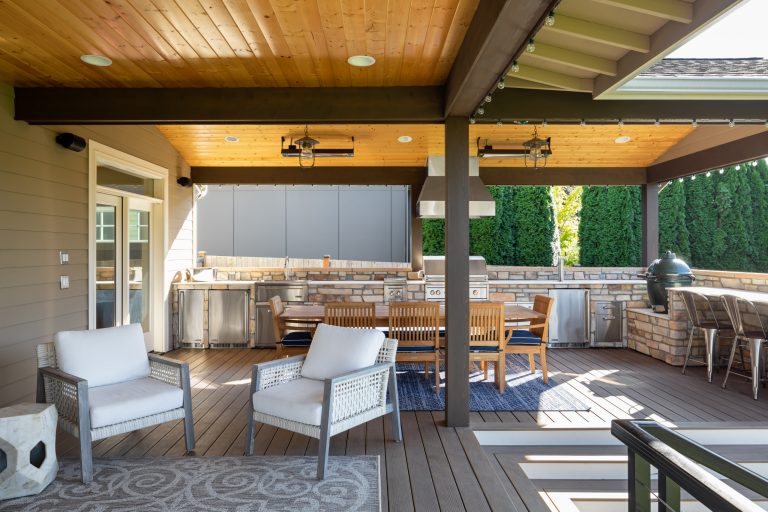 Outdoor kitchen complete with grill, refrigerators, sink, and ceiling heaters.
