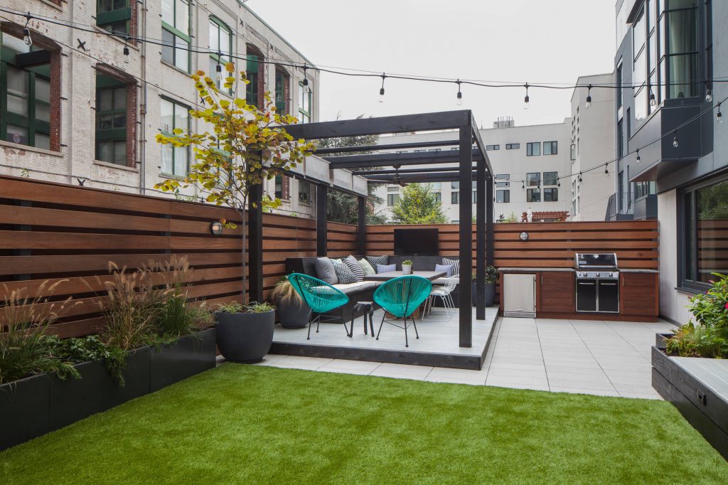Outdoor kitchen deck - contemporary outdoor kitchen deck idea in New York with a pergola