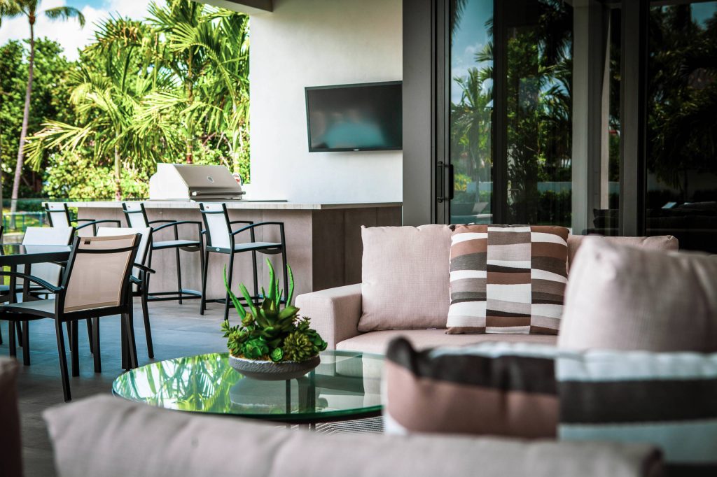 Outdoor kitchen deck - large contemporary backyard outdoor kitchen deck idea in Miami with a roof extension