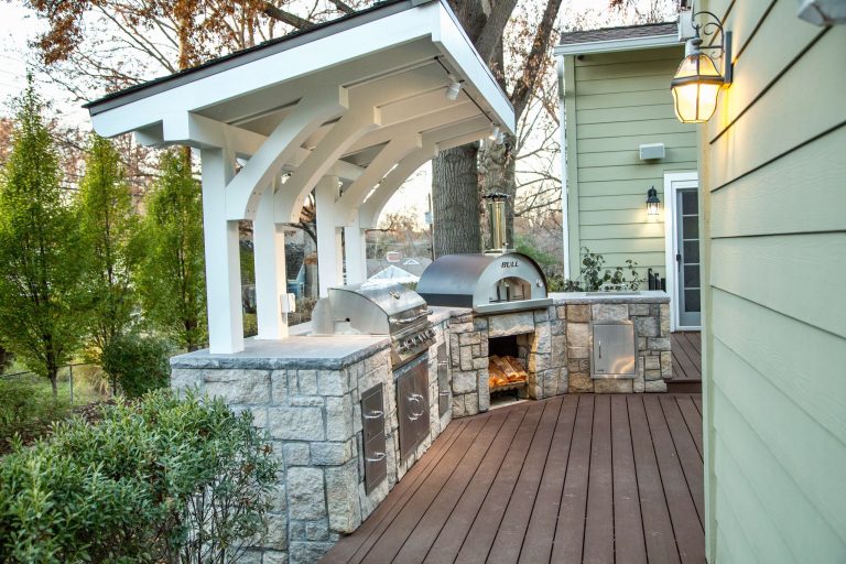 Outdoor kitchen deck - mid-sized traditional backyard outdoor kitchen deck idea in Kansas City with a pergola