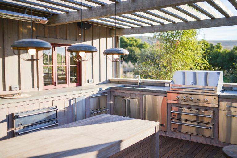 Outdoor kitchen & dining deck features Viking appliances and easy access to kitchen through the snack bar style window.