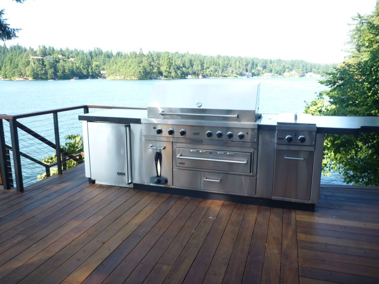 Outdoor kitchen with some curvy concrete countertops overlooking Lake Oswego