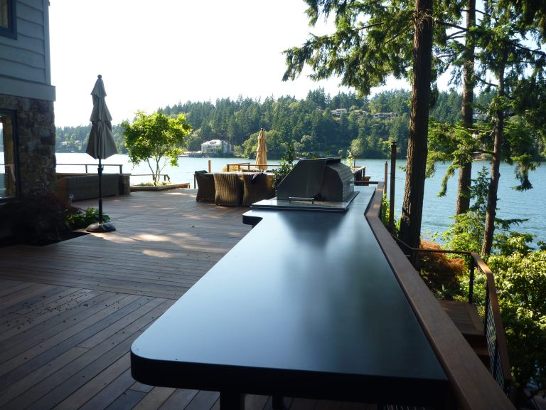 Outdoor kitchen with some curvy concrete countertops overlooking Lake Oswego