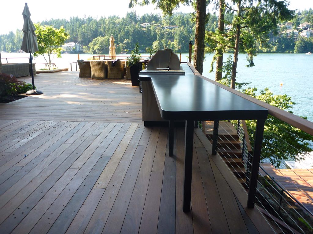 Outdoor kitchen with some curvy concrete countertops overlooking Lake Oswego