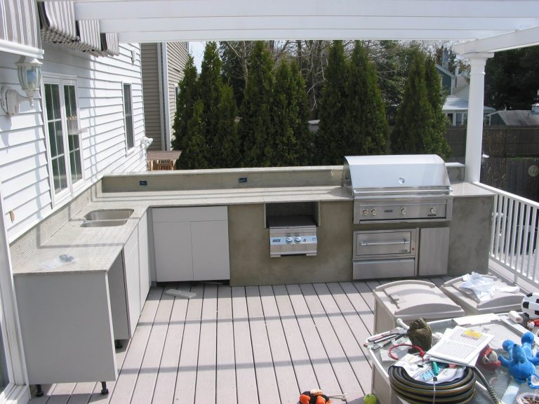 Outdoor living space on the deck featuring stainless steel built in grill with sink, fridge space, and storage.