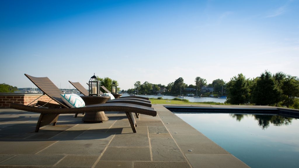 Outdoor pool with lounge chairs and water views. David Burroughs