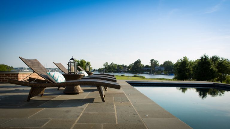 Outdoor pool with lounge chairs and water views. David Burroughs