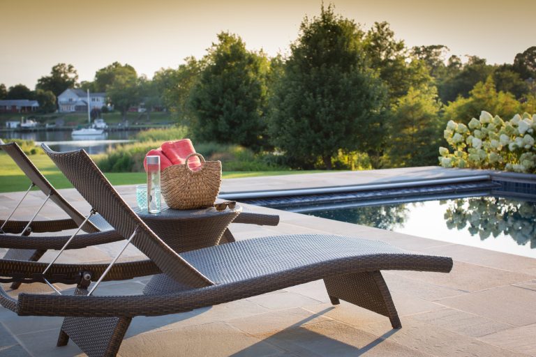 Outdoor pool with lounge chairs and water views. David Burroughs