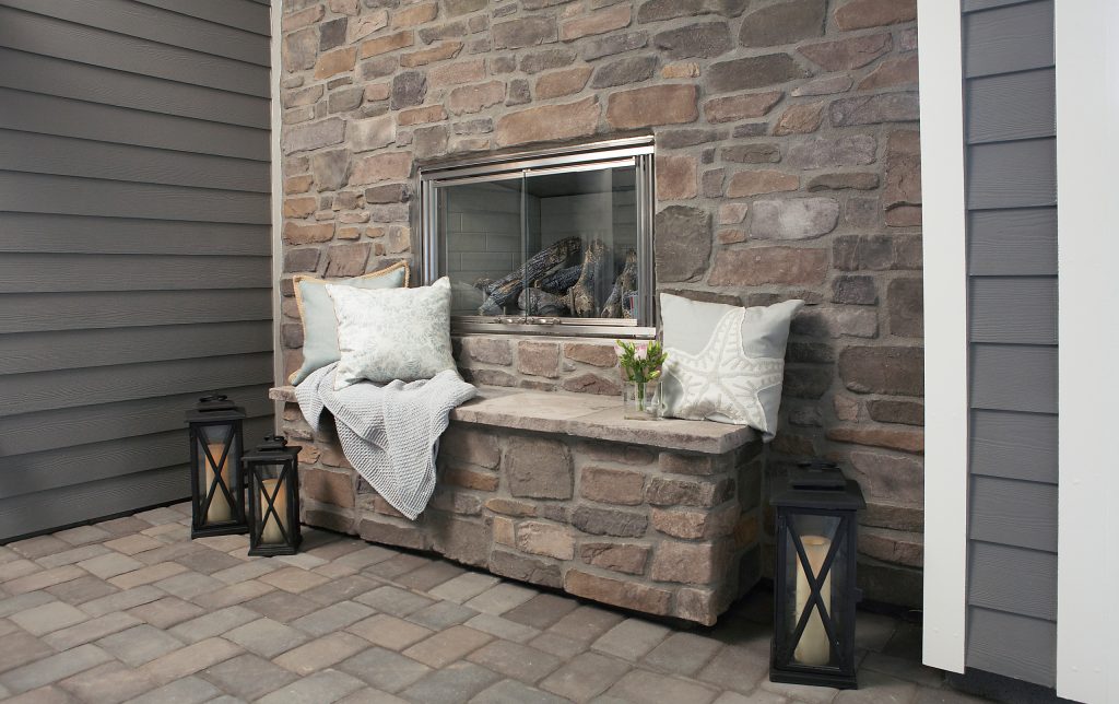Outdoor rock fireplace in covered loggia.