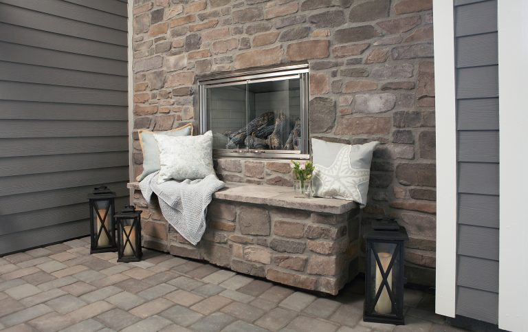 Outdoor rock fireplace in covered loggia.