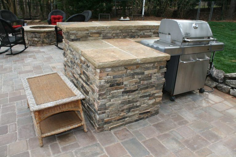 Outdoor stone grill area featuring a bar and cooking space with the frame covered by Daco's Real Stone Veneer