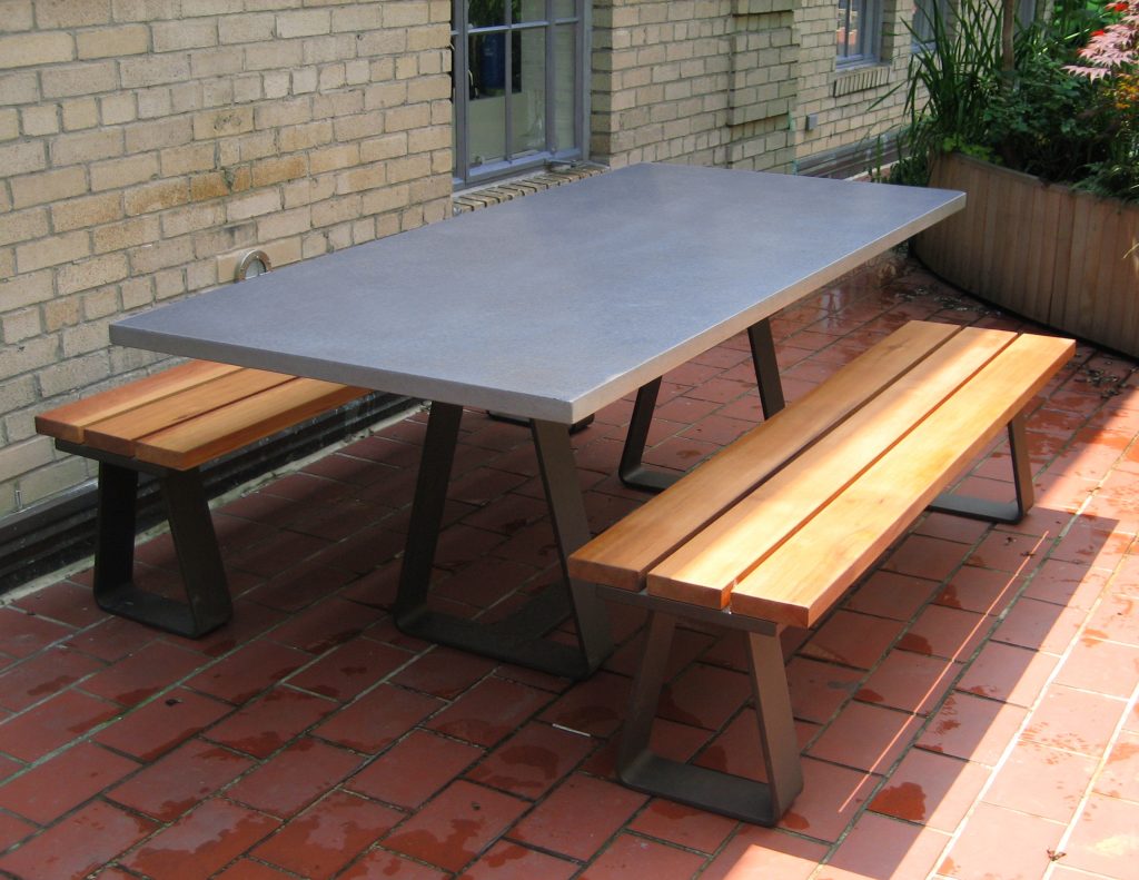 Outdoor table with a concrete table top and a custom steel base. Concrete Tables & Table Tops -Trueform Concrete Custom Work