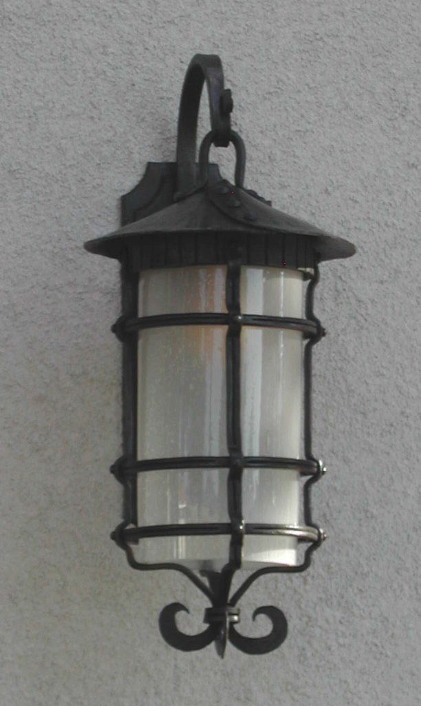 Outdoor wrought iron light fixture with hand blown seed glass.