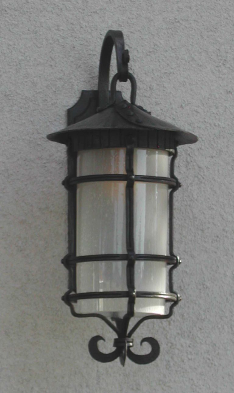 Outdoor wrought iron light fixture with hand blown seed glass.